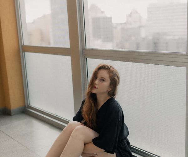Woman stretching near large window with soft morning light